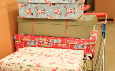 Gestapelte Weihnachtspakete auf Einkaufswagen, humedica Spendenaktion
