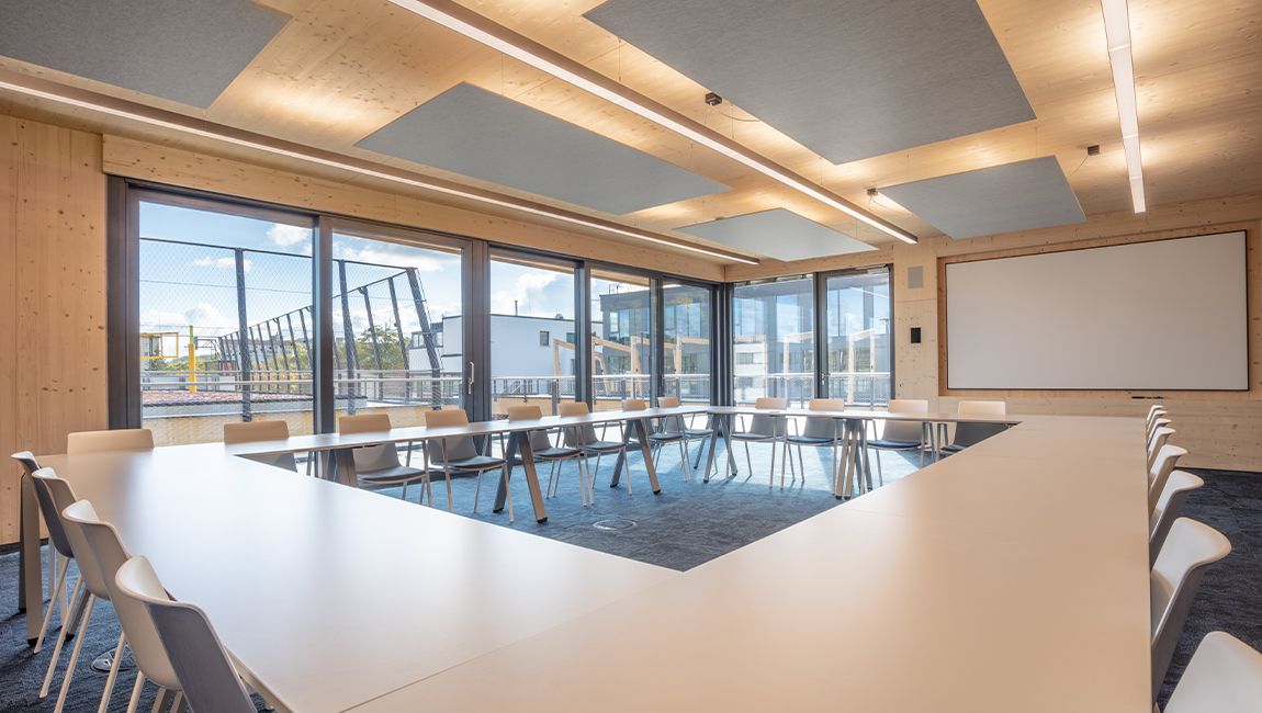 Großer SPRINTIS Besprechungsraum im Holzbau mit U förmiger Tischanordnung und Glasfront
