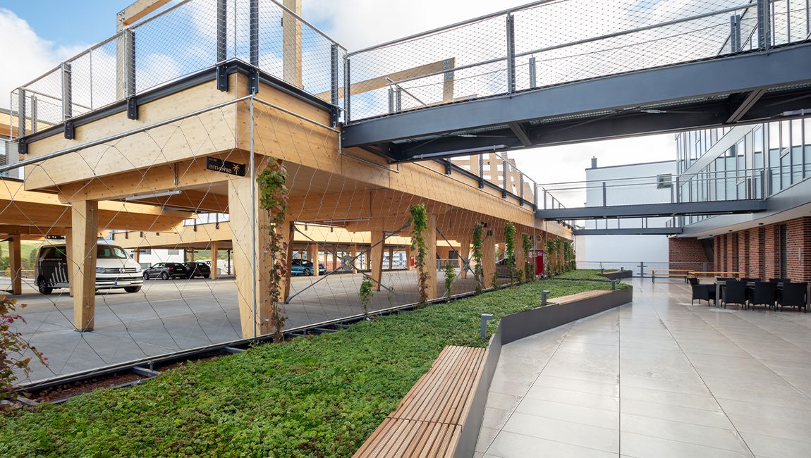 Chill Area mit begrünter Fläche, Holzbau, Brücken und moderner Architektur